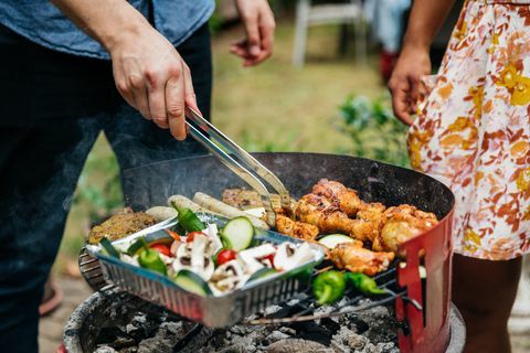 Közelkép az ember főzés étel a BBQ