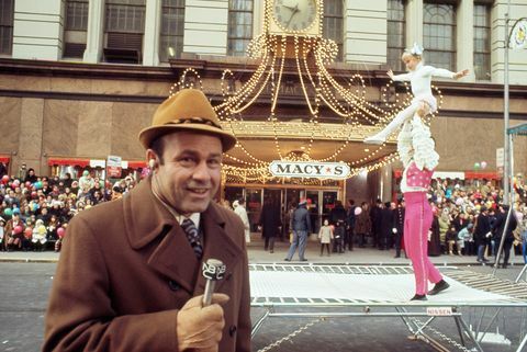Joe Garagiola mikrofonba beszél akrobatákkal a háttérben a Macy's hálaadás napi felvonulásán 1970-ben