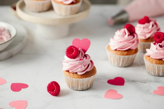 frissen készült málnás cupcakes a konyhapulton finom megjelenésű rózsaszín cupcakes málna és papír szív öntettel