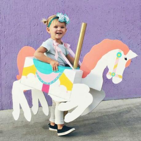 kislány, egy doboz alakú és festett, hogy körülötte körhinta ló legyen