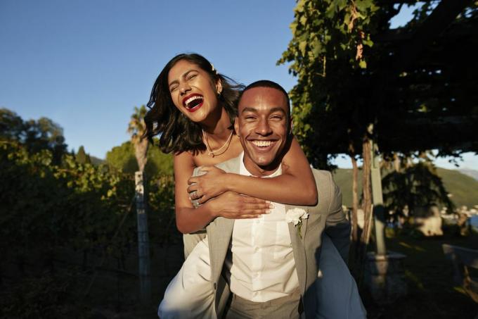 nevető férfi piggybacking nő a szőlőben