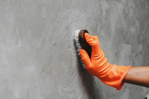 Körülvágott keze ember szürke fal tisztítása