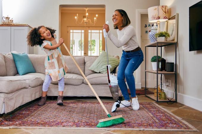 felvétel egy anyáról és lányáról, akik szórakoznak a nappali takarítása közben