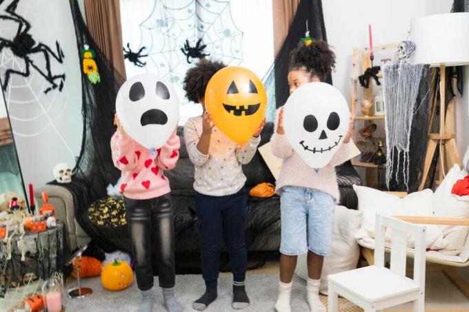 boldog kaukázusi fehér és afro-amerikai gyerekek halloween party a házukban