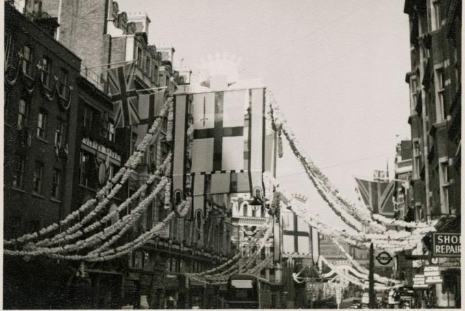 Flotta utca, londoni város, nagyobb londoni hatóság, 1953 épületeken függő zászlók képe és a Flotta utca közepén, ahonnan dekorációk vannak felfűzve, Erzsébet II. Erzsébet megkoronázása 1953. június 2-án történt, ezen a fényképen a flottautca közepén lógó zászlók London városa, ahol a St Georges Cross bal felső negyedében egy vörös kard látható képeket