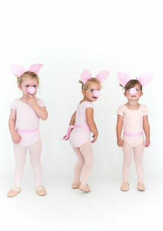 kislányok rózsaszín harisnyában és egybetétes disznófüllel és disznópofával