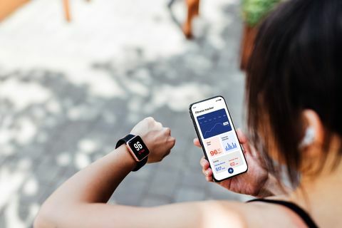 fiatal nő fitness tracker alkalmazást használ intelligens karórán és okostelefonon