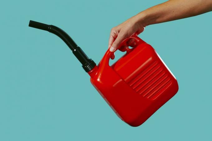 egy piros benzines kannából készül benzint önteni