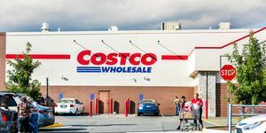 Fax-emberek élelmiszerekkel teli bevásárlókocsikkal, termékekkel sétálnak ki a virginia-i Costco üzletből a parkolóban